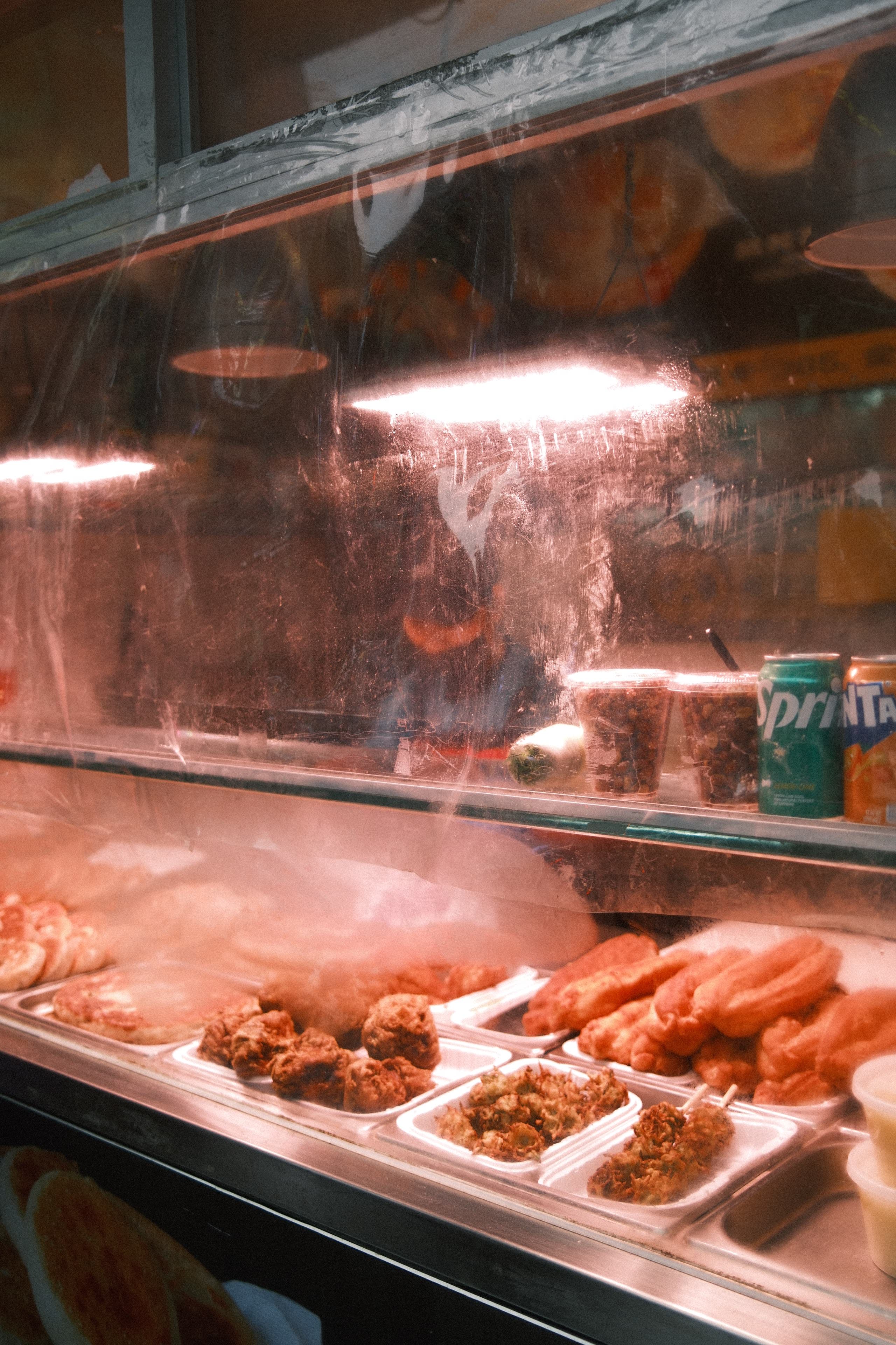 Late-night food stand behind a scratched window